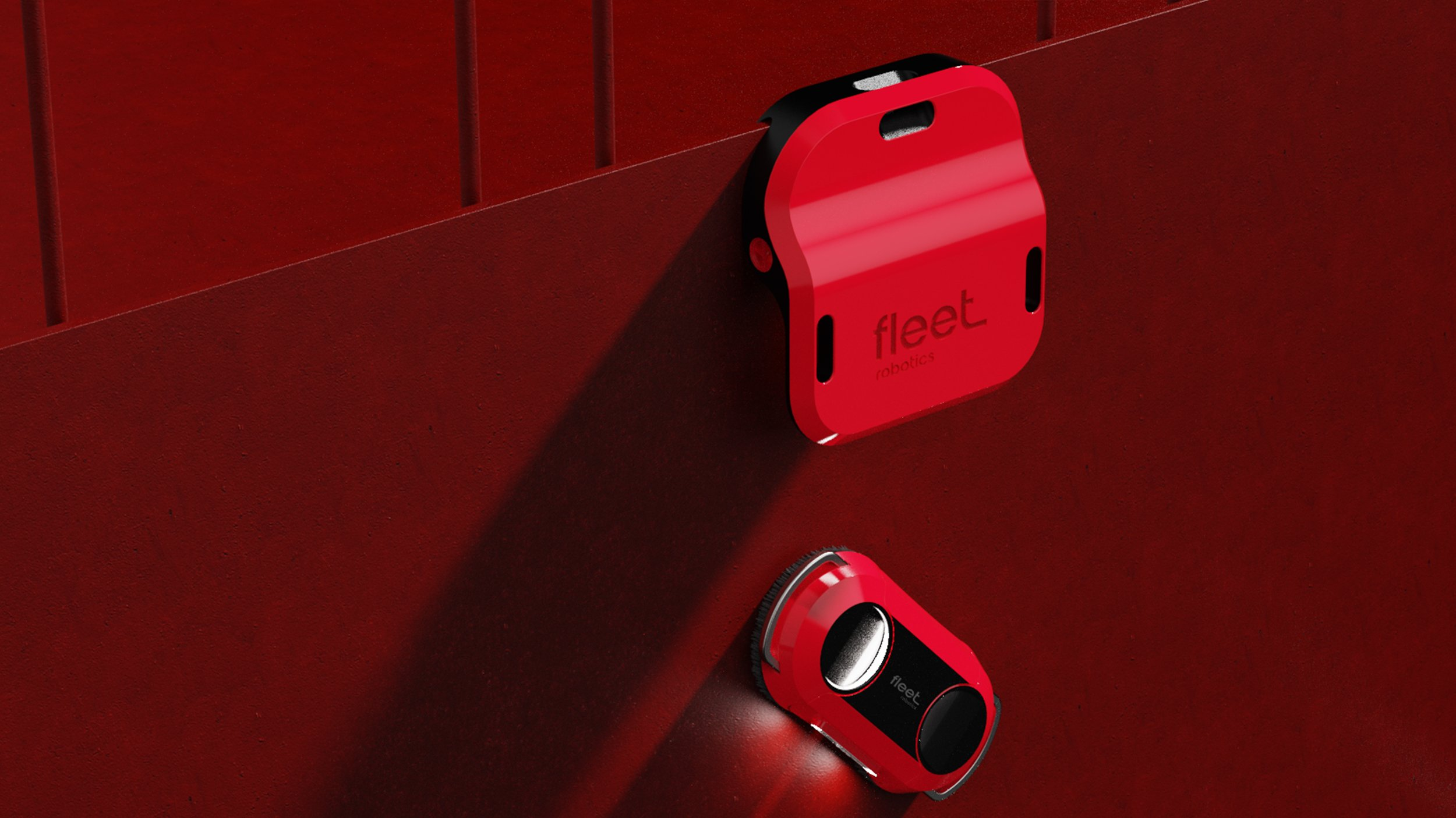 Fleet Robotics underwater robots against a red wall