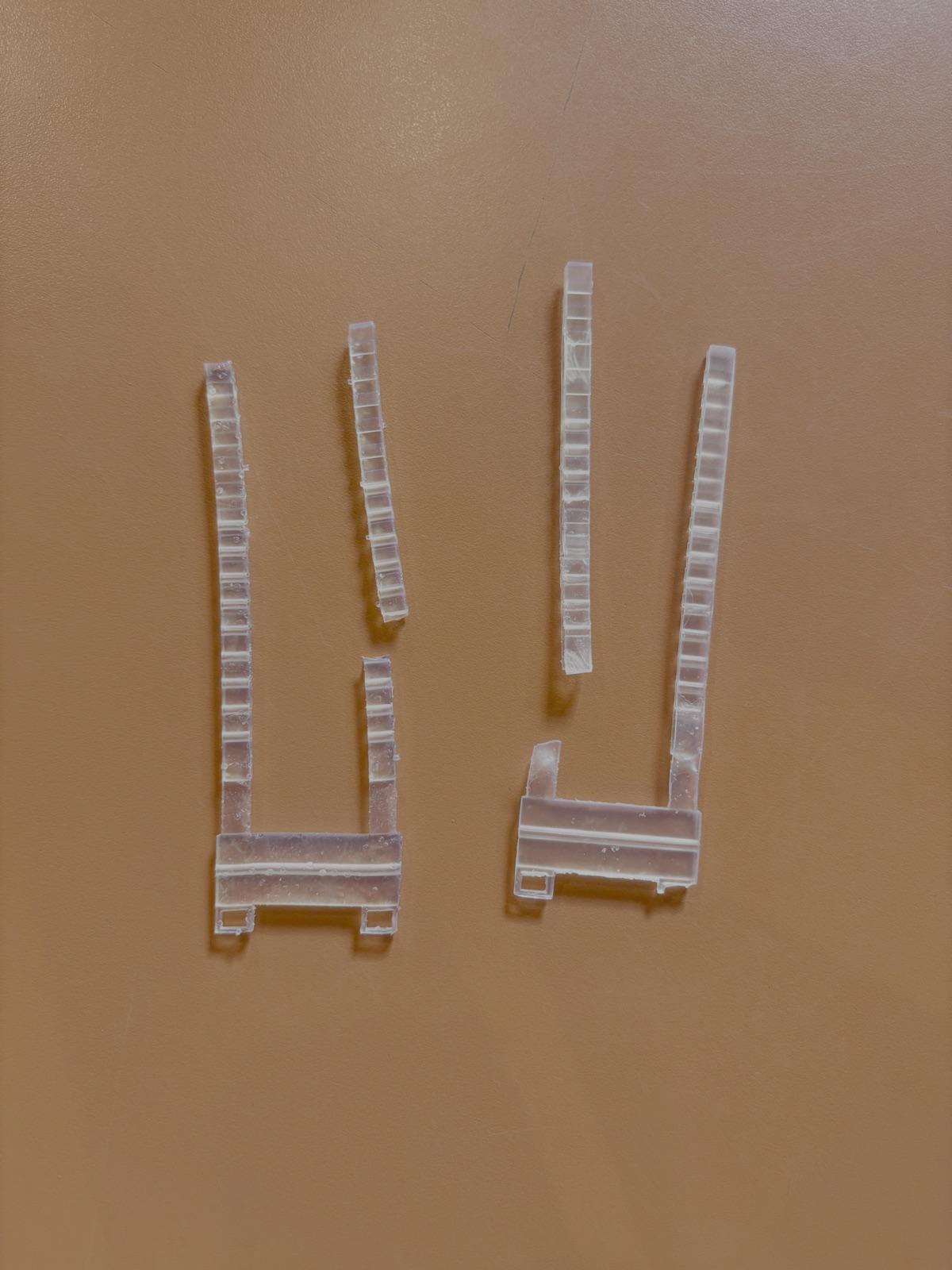 Two failed transparent resin transmission pieces from the wearable prototype