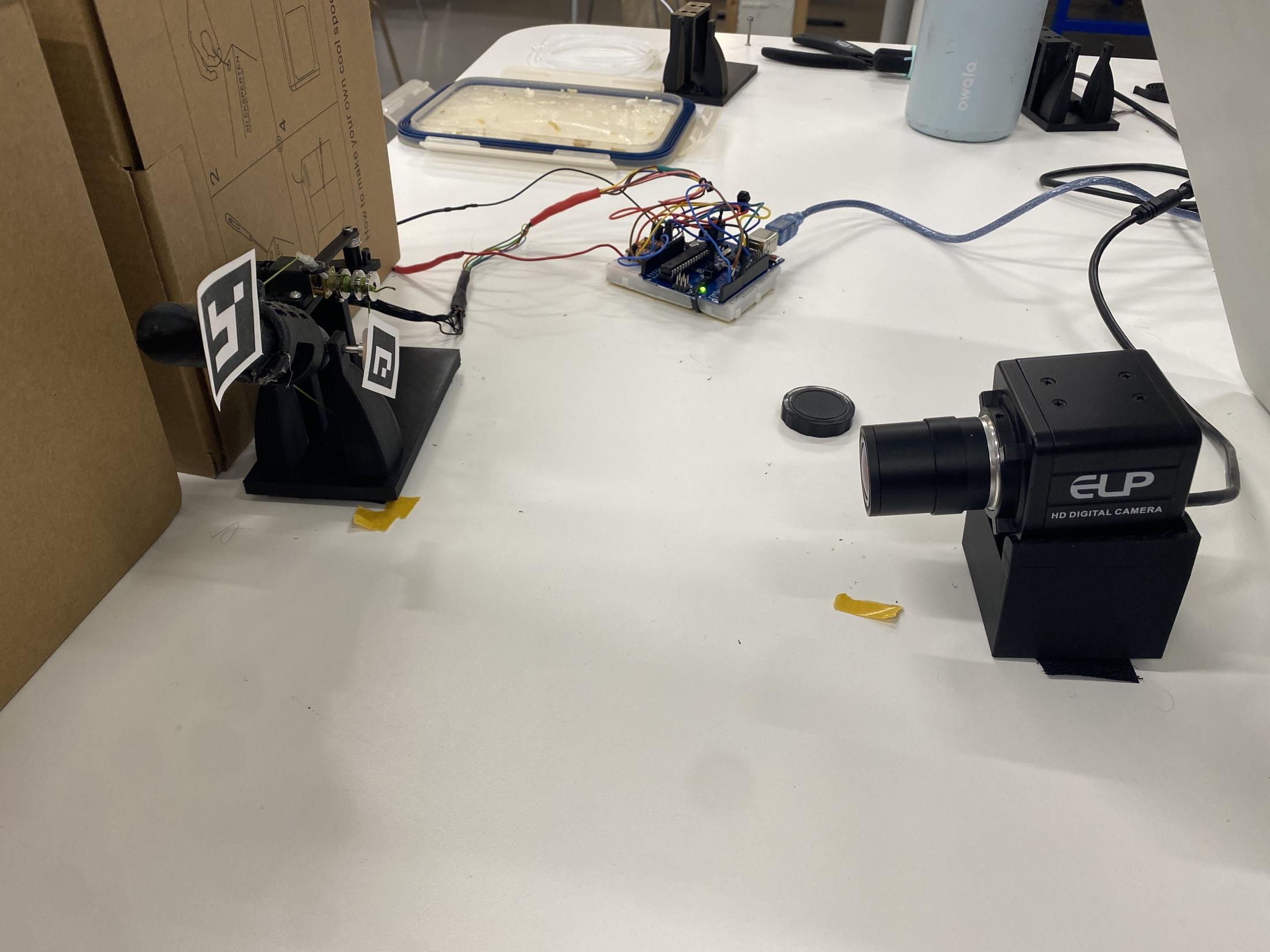 Thesis test setup with finger fixture, Arduino controller, encoder wiring, and camera measurement system